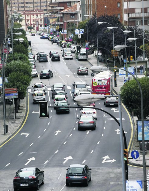 Avenida de Pablo Iglesias con abundante tráfico de vehículos y, al fondo, la plaza de toros de El Bibio.